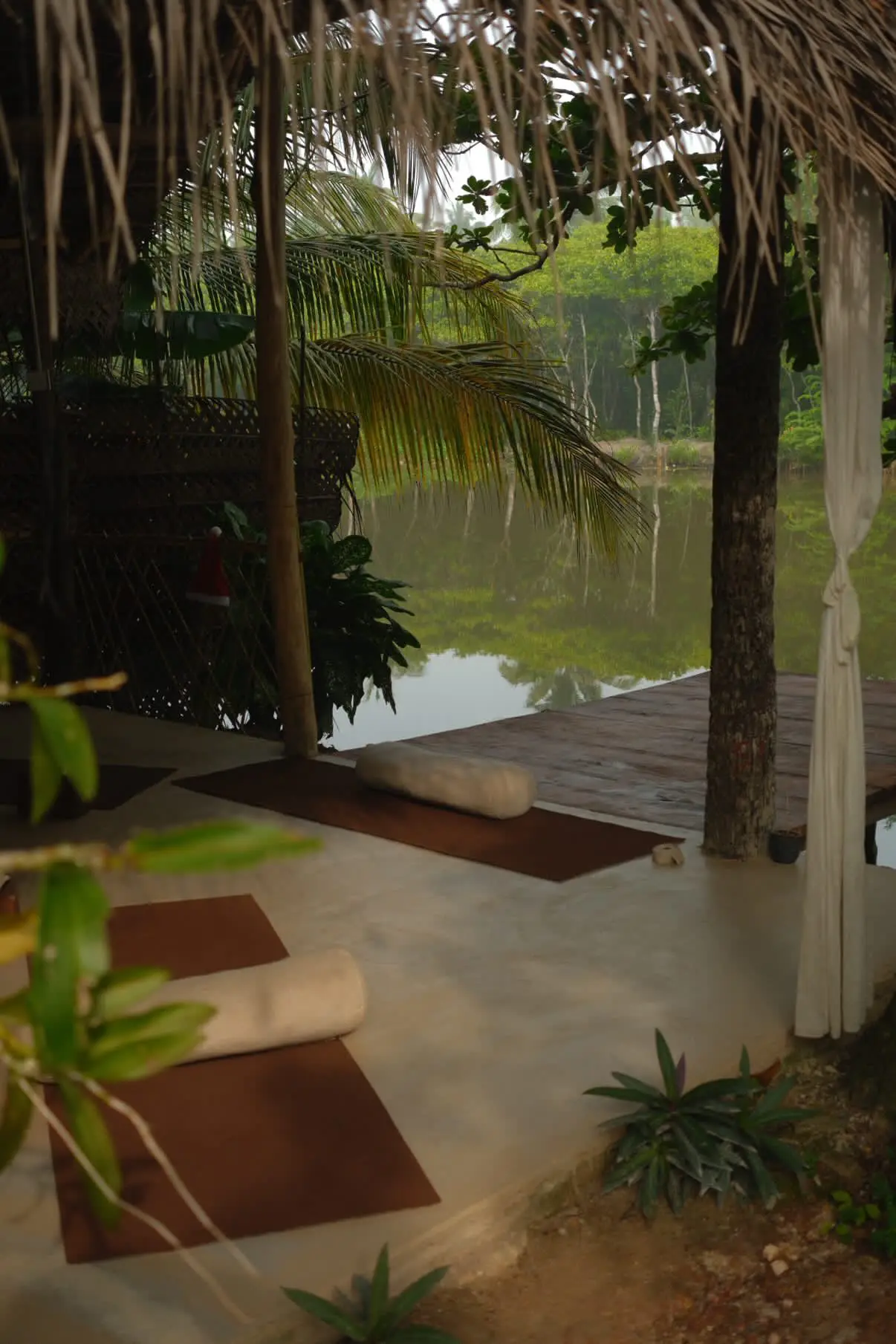 The shala's deck reaching out over the lagoon, framed by palms